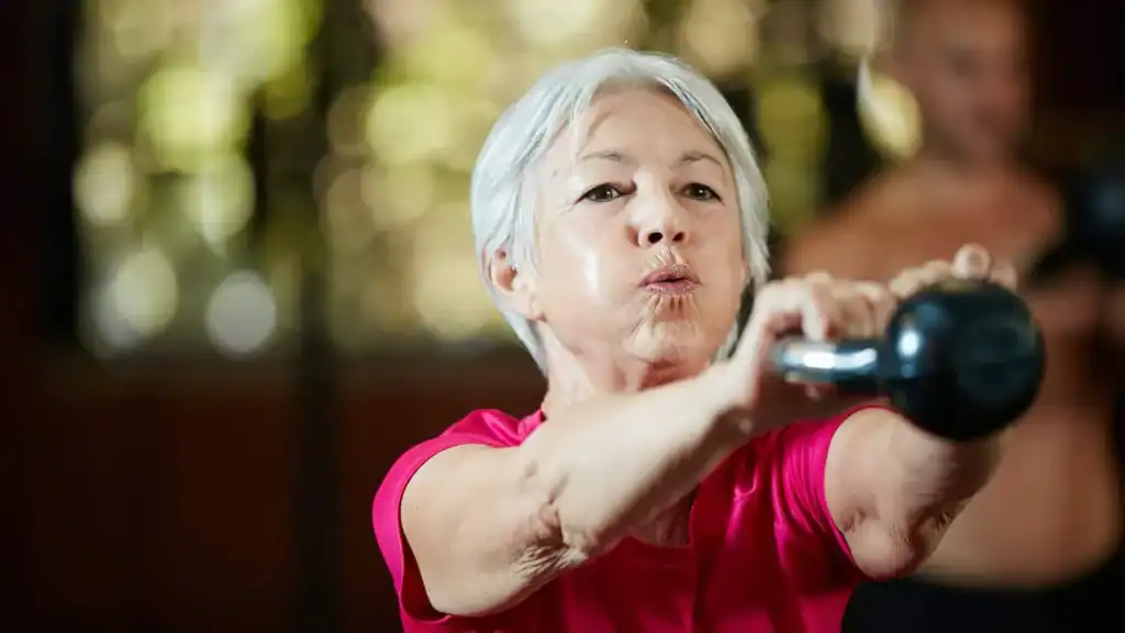 Older woman doing weight training Amersham to help her strength and longevity 