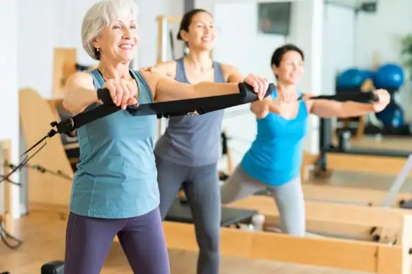 Toning Arms After 60: Empowering Womens Fitness Through Effective Weight Training 2 older woman doing weight training Amersham and resistance in the gym to tone upper arms
