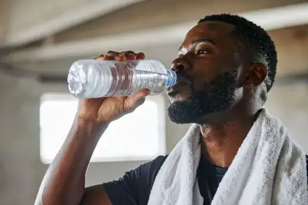 Hydration: The Secret Ingredient for a Toned Stomach and Enhanced Fitness 1 Image of man drinking water to improve hydration Amersham after work out.